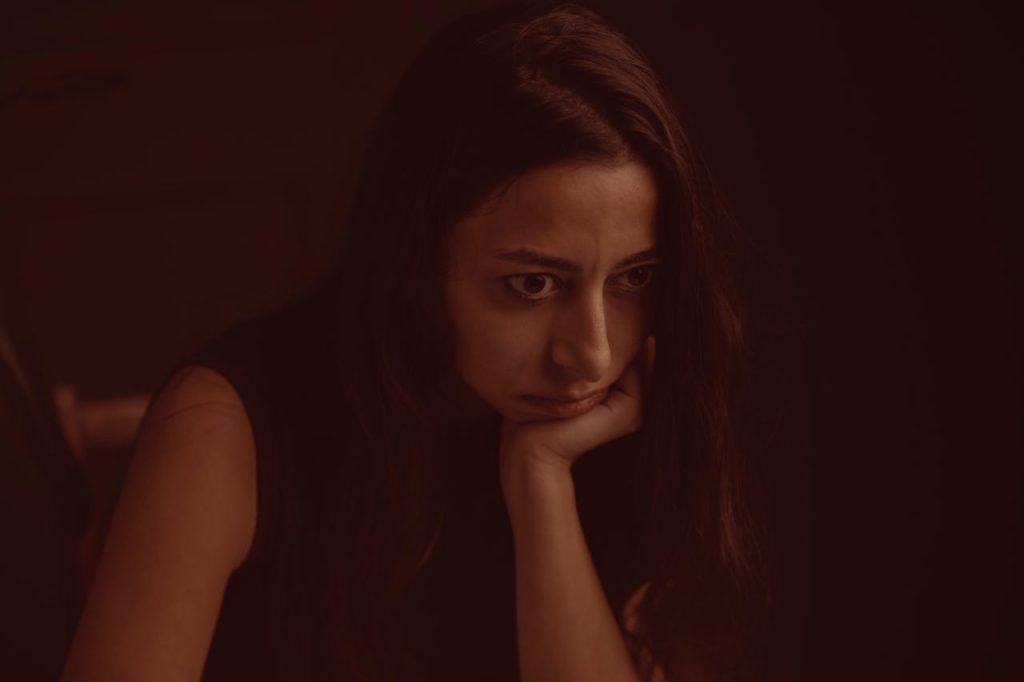 Woman sitting alone, reflecting on life changes after divorce