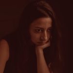 Woman sitting alone, reflecting on life changes after divorce